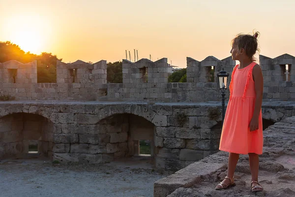 Una niñita mira el sol poniente. Mandraki, Ciudad Vieja, Rodas — Foto de Stock