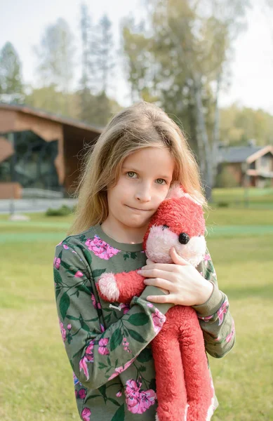 Mała dziewczynka z czerwoną zabawką miękki króliczek — Zdjęcie stockowe