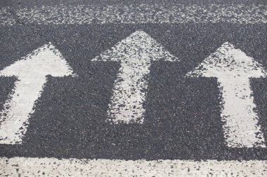Gri asfalt zemin üzerinde bir yönde üç beyaz oklar. Yön, kavşak, kavşak, crossway yürüme