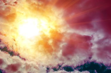 Kırmızı, turuncu ve kırmızı güneş ışınları kümülüs bulutların arasından bak. Soyut. Arka plan.