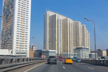 Yüksek katlı binaların bir arka plana dayanır yol boyunca hareketli araçların görünümü.