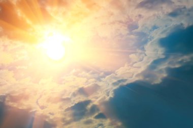 Mavi gökyüzünde parlayan parlak güneş ışınları. Bulutlar. Arkaplan.