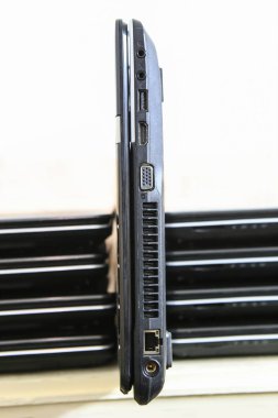 Dizüstü bilgisayarlar bir yığın. Ağ ve Usb girişleri ile dikey olarak bir loptop ayakta. Portre.