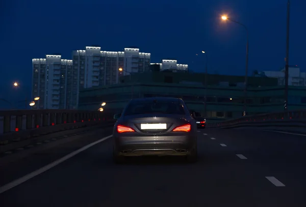 汽车夜间在城里的一座桥上行驶 — 图库照片
