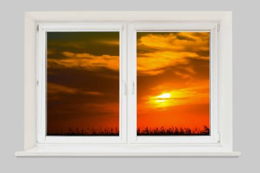 alan üzerinde bulutlu gökyüzünde pencereden gün batımı görünümü