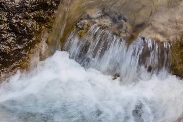 Flujo de agua entre las rocas de un arroyo de montaña —  Fotos de Stock