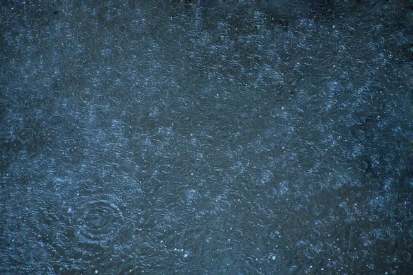 Krople deszczu spadające w basenie — Zdjęcie stockowe