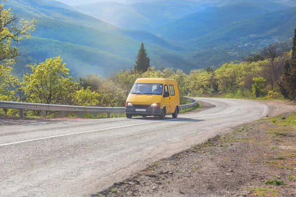 Minibus se pohybuje po silnici do vysočiny. — Stock fotografie