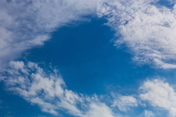Mavi gökyüzünde beyaz bulutların oval çerçevesi. — Stok fotoğraf