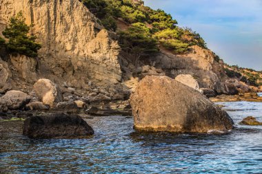 dağ manzarası ve deniz kıyısında büyük kayalar