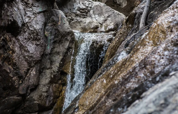 Flusso d'acqua tra le rocce di un torrente di montagna — Foto Stock