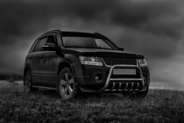 SUV op het veld onder een bewolkte hemel. — Stockfoto