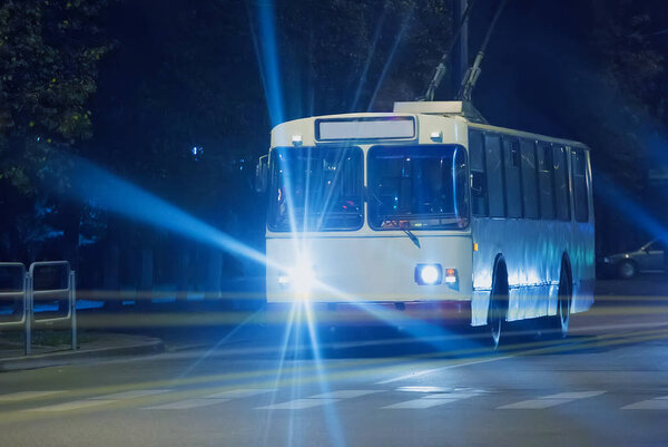 trolleybus goes at night down street