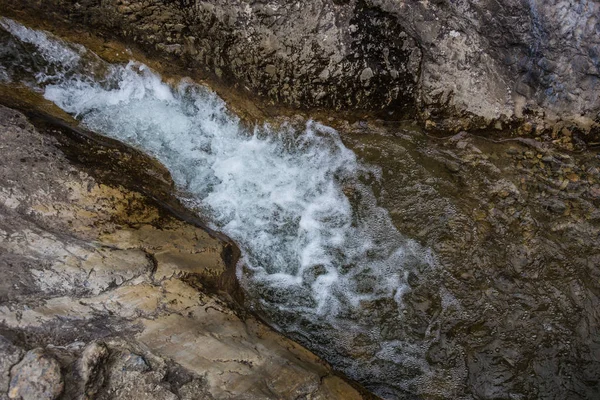 Flusso d'acqua tra le rocce di un torrente di montagna — Foto Stock