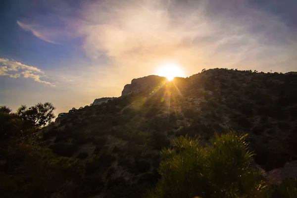 Tramonto nel cielo nuvoloso sopra la montagna — Foto Stock