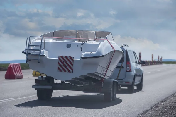 Auto mit Anhänger trägt ein Motorboot — Stockfoto