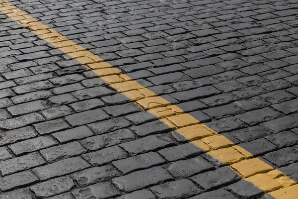 Granieten plaveisel met een gele streep op de diagonaal. — Stockfoto