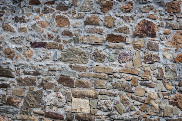 Stone wall of rough unprocessed stones — Stock Photo, Image