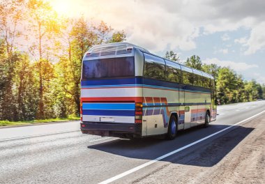 Şehirler arası otobüs güneşli bir günde taşra yolunda ilerliyor.