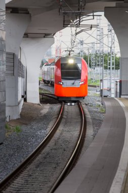 Modern kırmızı tren tren tren istasyonuna yaklaşıyor.