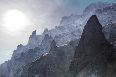 Şafak vakti, güneşin aydınlattığı deniz kıyısındaki uçurumlar