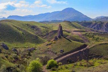 Güzel bir yaz manzarası. Dağlık bir bölgedeki bir uçurumun yakınındaki toprak yol.
