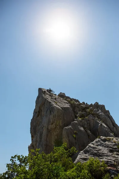 太陽の光で照らされた青い空の下の高い崖 — ストック写真