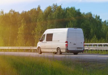 Minibüs orman boyunca otoyola çıkıyor.
