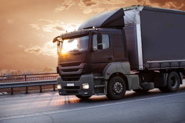 Kamyon gün batımında otoyola çıkıyor.