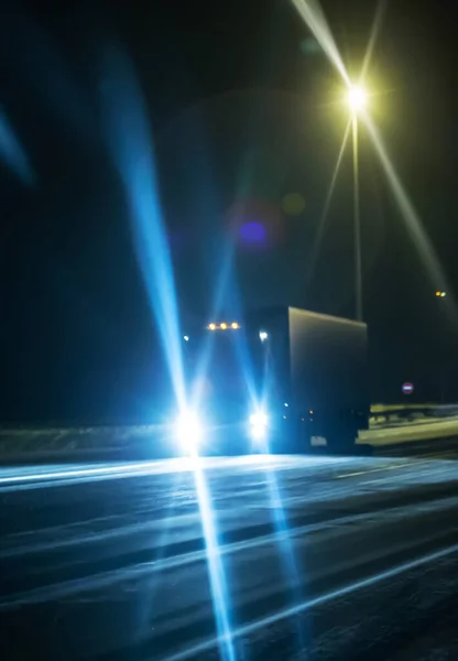 Truck on winter night is moving along the highway