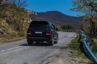 SUV dolambaçlı bir dağ yolunda ilerliyor.