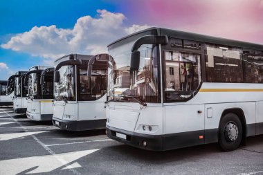 Bulutlu gökyüzünün arka planında büyük turist otobüsleri