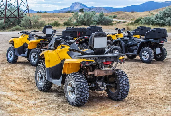 ATVs in the parking lot in the field near the mountains