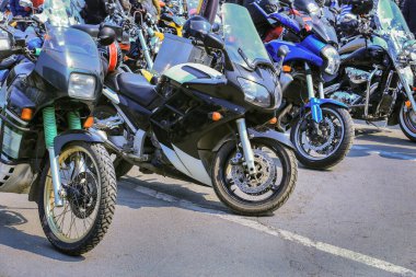 Motorsikletler asfaltta park halindeler.