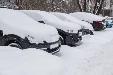 Otoparkta arabalar, kışın karda.