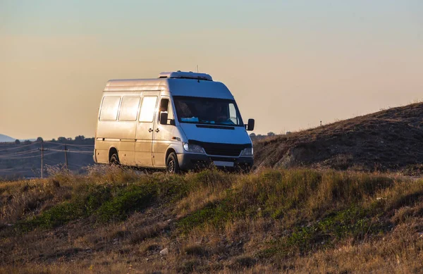 Minivbus Przenosi Się Wzgórza Drodze Zachodzie Słońca — Zdjęcie stockowe