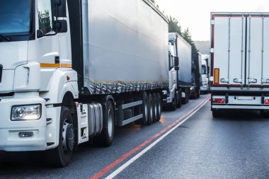 Banliyö otobanında trafik sıkışıklığında kamyonlar. Malların teslimi gecikmeli.