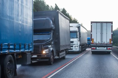 Banliyö otobanında trafik sıkışıklığında kamyonlar. Malların teslimi gecikmeli.