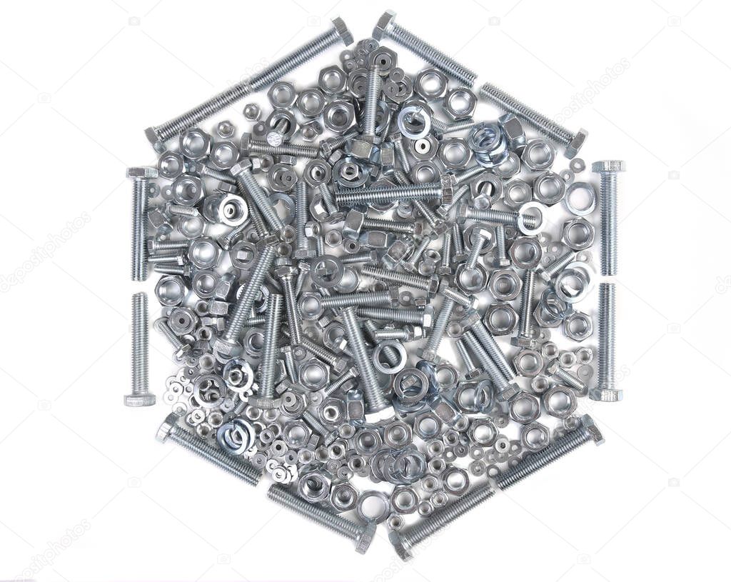 Metal bolts nuts and washers on a white background in the shape of a hexagon close-up