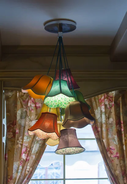 Antique beautiful chandelier on the ceiling against the window with curtains