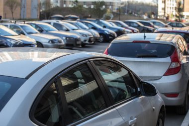 Bir apartmanın avlusunda kaldırıma park etmiş arabalar.