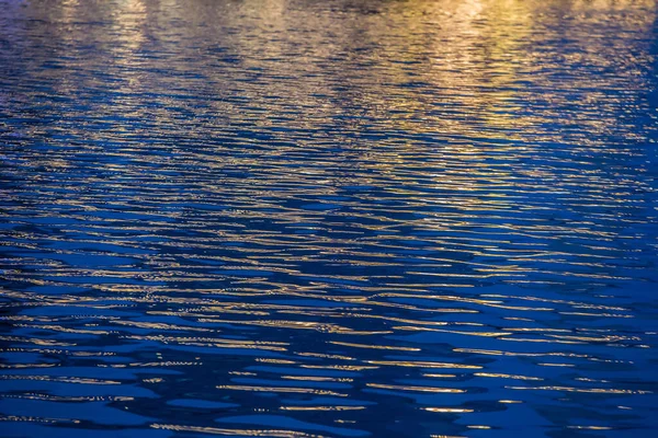 Riak Permukaan Air Biru Diterangi Oleh Cahaya Emas Latar Belakang — Stok Foto