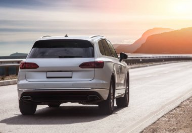 Gün batımında deniz kıyısındaki bir yolda kesişir.