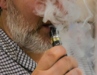 Yetişkin adam elektronik sigara içiyor. Vape. Ayrıntıları kapat.