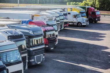 Gün doğumunda bir kır yolundaki otoparkta kamyonlar