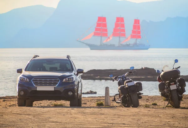 Dağlardaki Lagünün Kıyısında Araba Motorsikletler Yollarda Kırmızı Yelkenli Bir Yelkenli — Stok fotoğraf
