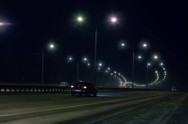 Kış karayolu gece lambalarla parıldıyor.