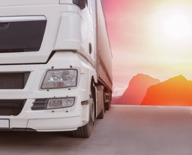 Kamyon, güneşli gökyüzünün arka planına doğru ilerliyor.