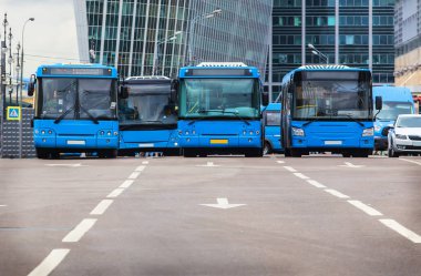 Otobüsler şehir merkezinde çok şeritli bir cadde boyunca hareket ederler.