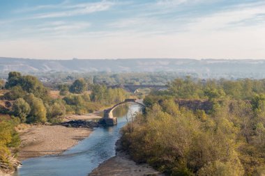 Sonbahar zaman içinde küçük bir nehrin karşısındaki eski yıkık Köprüsü